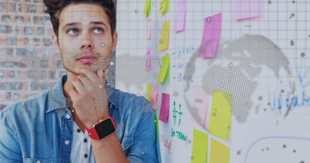 Analyst touching chin contemplating whiteboard diagrams in office, with sticky notes, copy space. Creative thinking, teamwork, brainstorming, innovation, modern workspace, conceptual, strategic planningの写真素材