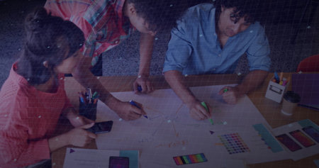 Collaborating colleagues sketching diagrams at small meeting room table, with colorful markers. Teamwork, brainstorming, creativity, innovation, discussion, office, collaborationの写真素材