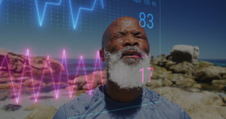 Catching breath man wearing blue workout shirt on rocky coast, with ECG waveforms '83' and '17'. Athletic, vitality, health, resilience, outdoor, fitness, determinationの写真素材