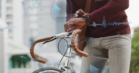 Cyclist gripping bike bars and adjusting smartwatch on sidewalk with maroon sweater and strap bag. Urban, active, fitness, lifestyle, casual, modern, transportationの写真素材