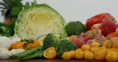 Presenting assorted fresh vegetables on wooden countertop, with cabbage half, broccoli florets. Fresh produce, healthy eating, farm fresh, organic, culinary, vibrant, naturalの写真素材