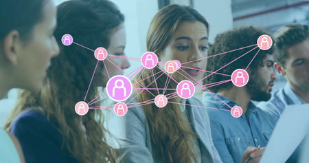 Five professionals reviewing paper documents in conference room with floating network icons....