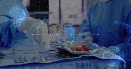 Arranging surgical tools on steel instrument tray under holographic globe overlay in operating room. Medical, healthcare, technology, innovation, precision, teamwork, sterileの写真素材