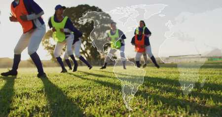 Running female soccer players practicing knee-raising in unison on turf at sunset, with neon bibs. Athletics, teamwork, fitness, outdoor, vitality, discipline, sportの写真素材