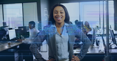 Smiling woman in blue blouse and gray blazer standing in modern office, with holographic panels. Professional, teamwork, collaboration, innovation, futuristic, workspace, diversityの写真素材