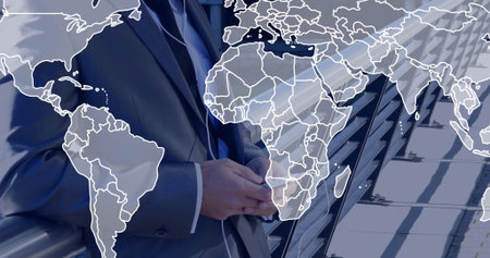 Standing man in dark suit clasping hands on rooftop terrace, with glass railing and map overlay. Corporate, skylines, professionalism, modernism, leadership, architecture, abstractの写真素材