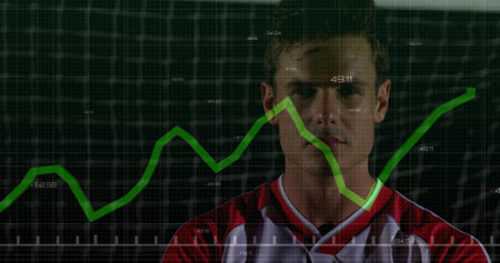 Standing baseball player wearing red and white jersey facing grid wall in studio, with green graph....
