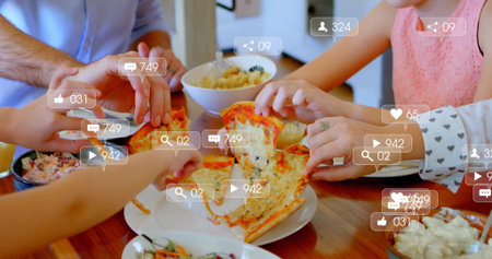 Reaching family members grabbing cheese pizza on dining table at home, with pasta salad and forks. Family, sharing, casual, rustic, wholesome, connection, celebrationの写真素材
