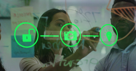 Woman in ribbed sweater sketching neon green icons on glass board in office, with sticky notes....