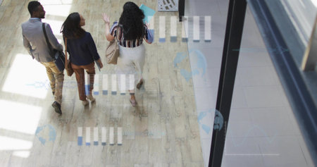 Walking team carrying shoulder bags, beige handbag and turquoise folder in sunlit office corridor. Professional, teamwork, modernity, collaboration, workspace, corporate, productivityの写真素材