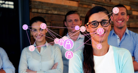 Posing 5-person team wearing business casual in office with plank wall, network overlay, copy space. Collaboration, teamwork, innovation, technology, workspace, professional, communicationの写真素材