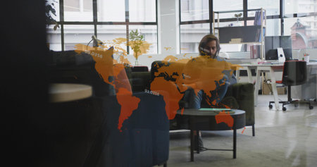 Holding smartphone on sofa in office lounge with coffee table, shelving, map overlay, copy space....