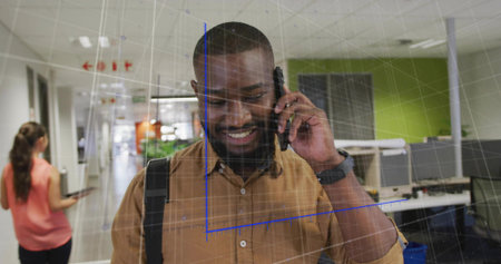 Talking smiling man holding smartphone and carrying backpack in office corridor with AR grid. Professional, communication, technology, collaboration, modern, innovation, workspaceの写真素材