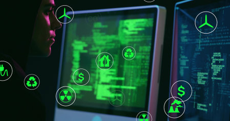Male analyst wearing hoodie analyzing green code in dim office, with floating eco icons, copy space. Technology, innovation, cybersecurity, futuristic, data visualization, environmental awarenessの写真素材
