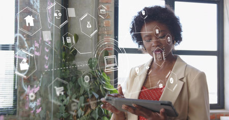 Blazer-clad woman analyzing finance icons on panel in office using tablet and stylus, copy space....