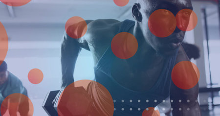 African American man wearing tank top performing single arm dumbbell row in gym, with red circles. Strength, fitness, workout, training, muscular, motivation, healthの写真素材