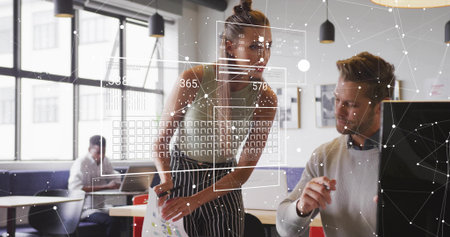 Leaning woman in sleeveless top reviewing printed charts at office, with digital data overlays. Collaboration, teamwork, modernity, productivity, business, innovation, technologyの写真素材