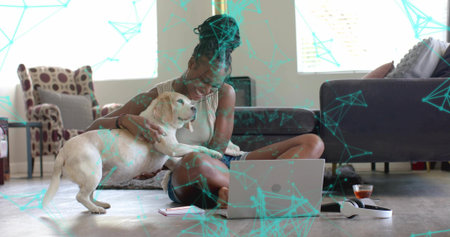 Petting white and tan dog, woman sitting on hardwood floor in living room, with open laptop. Cozy, domestic, lifestyle, casual, heartfelt, serene, modernの写真素材