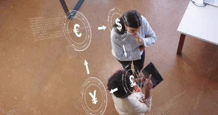 Executives wearing suits discussing financial data in office, tablet and currency icons, copy space. Professional, collaboration, futuristic, finance, urban, technology, teamworkの写真素材