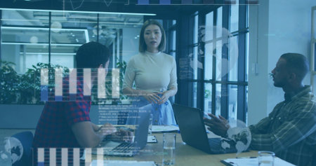 Presenting charts, Asian businesswoman in business attire speaking at conference table with laptops. Corporate, teamwork, innovation, modernity, collaboration, leadership, technologyの写真素材