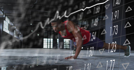 Man wearing red tank top pushing up on concrete floor in warehouse. Fitness, strength, industrial, modern, health, determination, perseveranceの写真素材