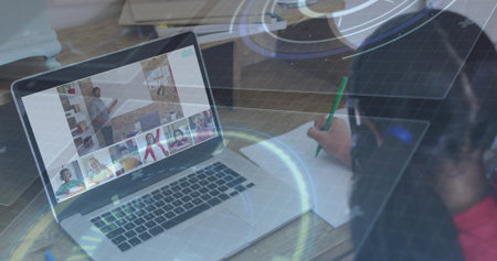 Girl wearing red shirt, headset scribbling in notebook with pencil at home, with laptop, copy space. Remote learning, online education, home classroom, digital interface, student engagementの写真素材