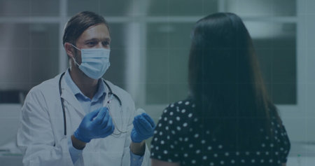 Male physician wearing mask and gloves administering injection at clinic, featuring syringe. Medical, healthcare, clinical, consultation, professionalism, hygiene, treatmentの写真素材