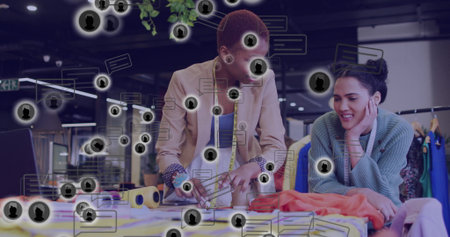 Cutting orange fabric, designer and assistant collaborating at design studio with scissors. Craftsmanship, collaboration, creativity, workspace, fashion, textiles, innovationの写真素材