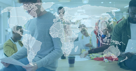 Collaborating design team of six reviewing global designs in studio, with laptop and garment racks. Collaboration, teamwork, innovation, modern, creative, brainstorming, diversityの写真素材