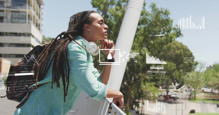 Leaning man on balcony railing monitoring data overlays over walkway, with headphones and backpack. Urban, technology, analytics, outdoors, workspace, communication, modernの写真素材