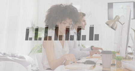 Typing colleagues in business attire analyzing data on monitors in office, with bar chart overlay. Collaboration, productivity, analytics, workspace, modern, teamwork, innovationの写真素材