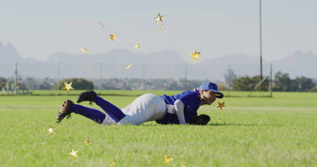 Lying baseball player wearing blue cap, jersey holding glove on grass field with stars, copy space. Athlete, sportswear, teamwork, outdoor, determination, celebration, vibrantの写真素材