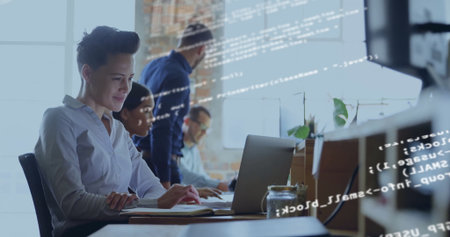 Collaborating professionals coding on laptop and desktop monitor at desk in office, copy space. Collaboration, teamwork, innovation, modern, workspace, creative, technologyの写真素材