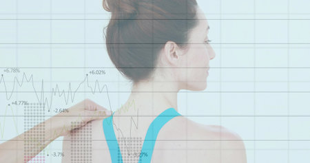 Adult patient in sports top getting shoulder adjustment by therapist in clinic, with chart overlay. Health, analytics, data, wellness, rehabilitation, progress, stabilityの写真素材