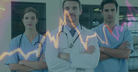Medical team standing with arms crossed in corridor, wearing uniform, stethoscopes and ECG overlay. Healthcare, professionalism, diagnostics, teamwork, hospital, medical equipment, clinicalの写真素材