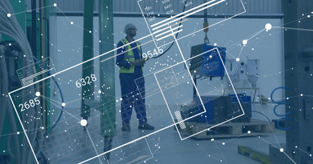 Factory tech in helmet and vest examining component hanging from crane hook, with data overlays. Industrial, manufacturing, safety, technology, precision, engineering, automationの写真素材