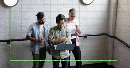 Leaning three professionals reviewing laptop on office stairwell with handrail, holding coffee cups. Collaboration, teamwork, business, workplace, modern, architecture, professionalismの写真素材