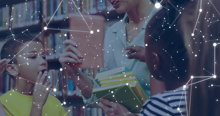 Teacher in button-down shirt holding hardcovers and flashcard in library, with children listening....