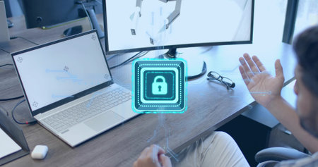Gesturing man in shirt touching holographic lock icon above desk, with laptop, monitor, copy space....