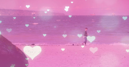 Walking man in jacket and jeans along sandy beach water's edge, with smartphone, copy space. Seaside, solitude, tranquility, romantic, reflection, nature, leisureの写真素材