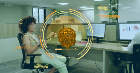 Demonstrating holographic orange brain, woman wearing blouse holding card in office with monitors....