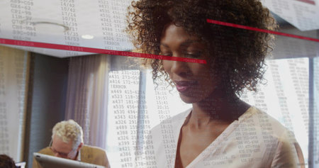 Reviewing woman in business casual blouse examining code at desk with streaming overlay, copy space....