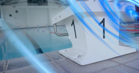 Highlighting white starting block labeled 1 on tiled deck shining under lights, ropes, blue streaks....
