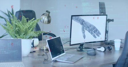Showing desktop monitor featuring robotic prosthetic hand in office, with laptops, copy space....