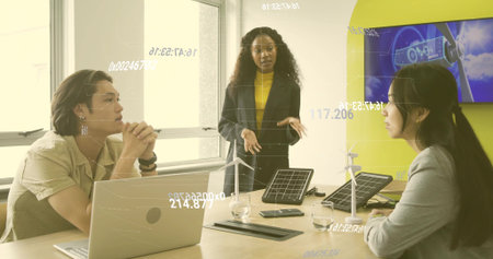 Presenting man in dark blazer leading meeting in conference room, with laptop and energy prototypes....