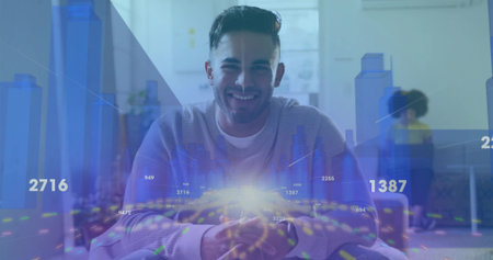 Smiling Asian man sitting at desk in bright open-plan office, with holographic data visualizations. Data analytics, collaboration, innovation, modern workspace, digital interface, business strategyの写真素材