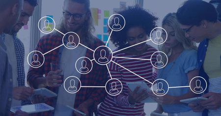 Team holding tablets smartphones and glass in bright office, with network overlay. Collaboration, teamwork, innovation, productivity, communication, brainstorming, digital connectivityの写真素材