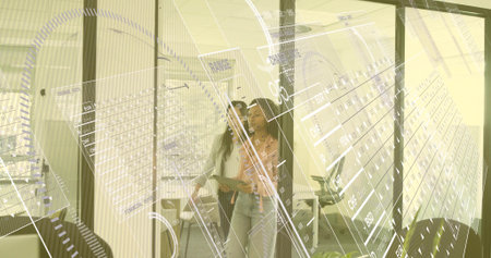 Walking two women coworkers viewing digital overlays through glass-walled corridor with smartphone....