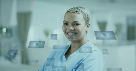 Standing doctor wearing scrubs smiling with floating digital panels in clinic with space graphics....