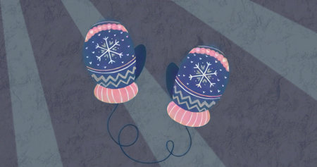Displaying blue mittens with snowflakes and pink cuffs connecting by navy cord on lit gray surface. Winter accessories, cozy, textured, craft, seasonal, handcrafted, simplicityの写真素材